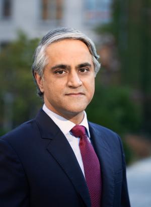 Man in suit and tie in front of a blurred building